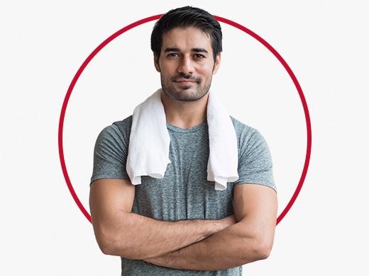 Muscular man with white towel around neck happy after Canesten sweat rash treatment