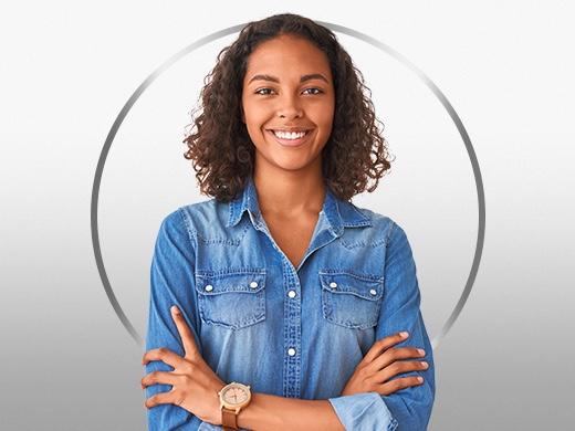 Young smiling woman with curly hair wearing blue shirt happy after Canesten cystitis treatment